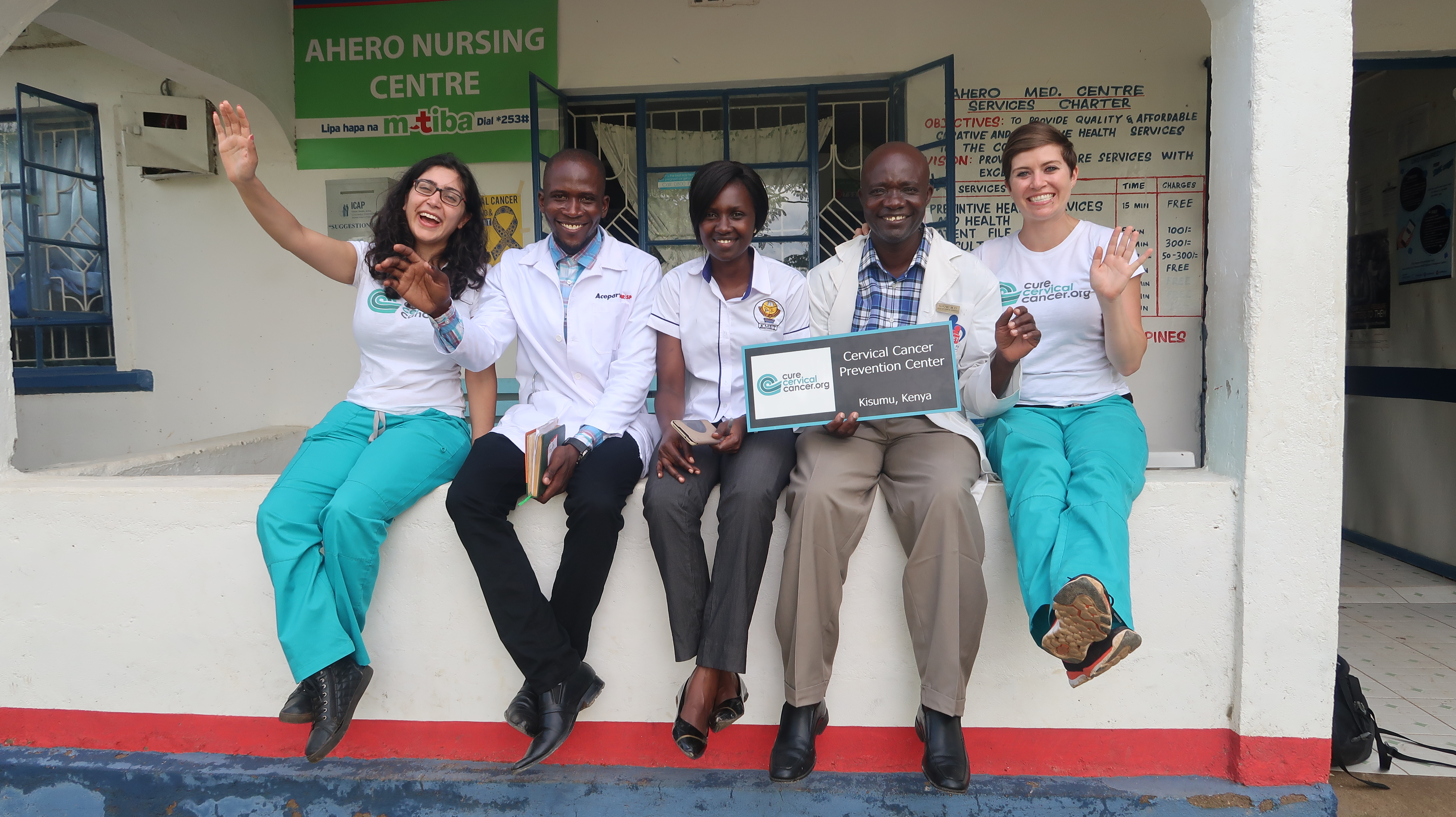  Global Trainees Jeff and Maurice sit with the CCC team in front of Ahero Hospital a newly established “See & Treat” site.